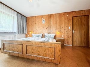 a bedroom with a large bed with a wooden wall at Haus Schönblick in Bschlabs
