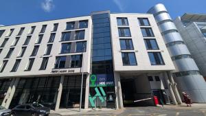 a large white building with a car parked in front of it at City HideAway in Galway