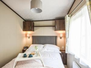 a bedroom with a bed with a table next to it at Avon Lodge in Hyssington +5 photos