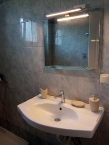 a bathroom with a white sink and a mirror at Blue Bay Club in Vrachonisída Omprélla