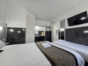 a hotel room with two beds and a flat screen tv at Fasthotel Tours Nord in Parçay-Meslay +36 photos
