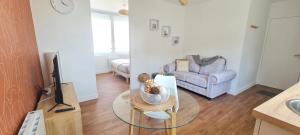 a living room with a table and a couch at Le Corail - centre-ville - TV in Pontivy