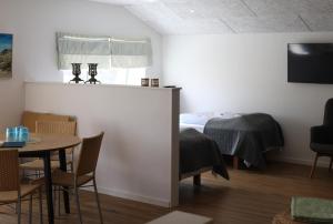 a room with a bed and a table and chairs at Lønstrup Strandhotel in Lønstrup