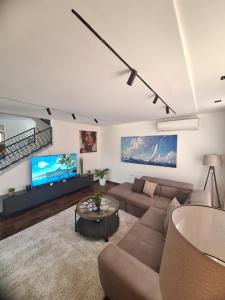 a living room with a couch and a tv at Vila Olive 51 in Tivat