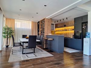 a kitchen and dining room with a table and chairs at Vila Olive 51 in Tivat