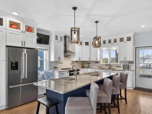 a kitchen with white cabinets and a large kitchen island at Mischief Managed NC in Oak Island