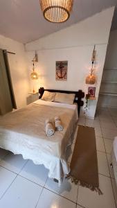 a bedroom with a bed with two slippers on it at Casa Folha Tropical in Pipa