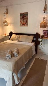 a bedroom with a bed with two towels on it at Casa Folha Tropical in Pipa