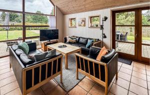 a living room with couches and a tv and a table at Pet Friendly Home In Rømø With Sauna in Rømø