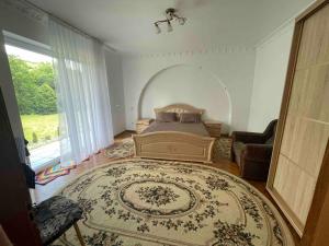a bedroom with a bed and a large window at Садиба "Віталія" in Volovets