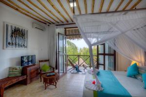 a bedroom with a bed with a mosquito net at Sultan Sands Island Resort & Spa in Kiwengwa