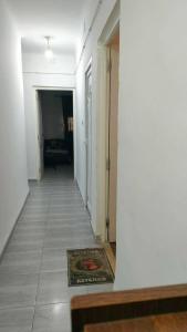 an empty hallway with a rug on a tile floor at Jijel in Jijel