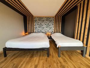 two twin beds in a room with wooden floors at Gite du Moulin Iris in Stavelot