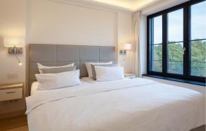 a bedroom with a large white bed with white pillows at Eden in Binz