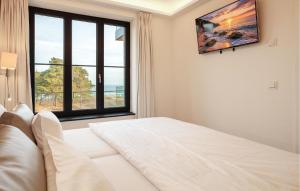 a white bedroom with a bed and a window at Eden in Binz