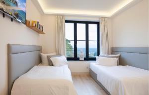 two beds in a room with a window at Eden in Binz +30 photos