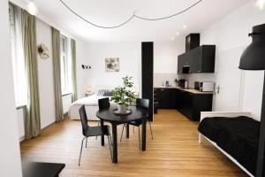 a living room with a table and a bedroom at Core Luxembourg City in Luxembourg