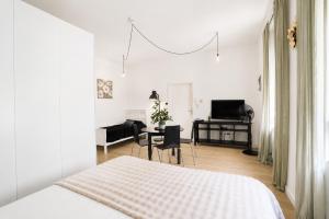 a white bedroom with a bed and a desk at Core Luxembourg City in Luxembourg