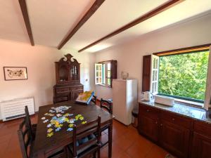 a dining room with a table and a refrigerator at Casa da Sofia in Ponte da Barca +15 photos