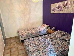 two beds in a room with purple walls at Villa La Marpierre in Mondragon +24 photos