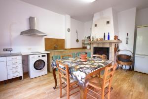 a kitchen with a table with chairs and a stove at Cuencaloft Villa Los Perales in Villalba de la Sierra