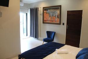 a bedroom with a bed and a painting of a zebra at Kanyane @ Graskop in Graskop