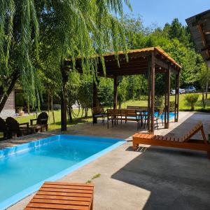 a swimming pool with a pavilion and a picnic table at Complejo La Cascada San Javier in San Javier