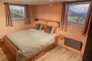 a small bedroom with a bed and two windows at Berghaus Weissbriach in Weissbriach +55 photos
