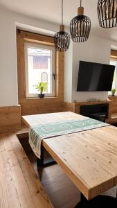 a living room with a wooden table and a flat screen tv at Coriva Homes - Cogolo in Cogolo