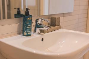 a bathroom sink with two bottles of soap and a razor at Maritimo Apartament przy Porcie by 2HomeRent in Kołobrzeg +22 photos