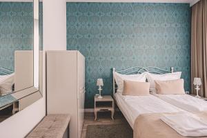 a bedroom with a bed and a blue wall at Maritimo Apartament przy Porcie by 2HomeRent in Kołobrzeg