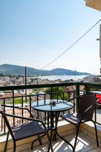a patio with a table and chairs on a balcony at Με συμπάθεια-With sympathy - private parking in Kavála