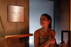 a woman standing in front of a mirror at Boutique Hotel Nives - Luxury & Design in the Dolomites in Selva di Val Gardena +94 photos