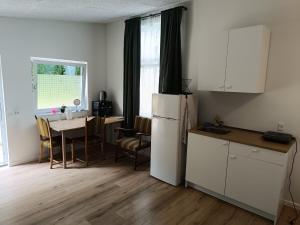 a kitchen with a white refrigerator and a table with chairs at Outside Ribe Guesthouse in Ribe