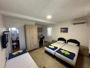 a bedroom with two beds and a television in it at Apartmani Čavor in Budva