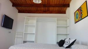 Schlafzimmer mit einem Bett, einem TV und Regalen in der Unterkunft Duplex la Delfina 1 in Villa Carlos Paz