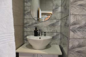a bathroom with a white sink and a mirror at Kanyane @ Graskop in Graskop +41 photos