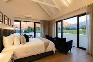 a bedroom with a bed and a large window at Kleine Banhoek Manor in Stellenbosch