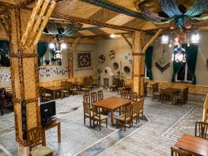 a dining room with wooden tables and chairs at Hotel Latif Samarkand in Samarkand