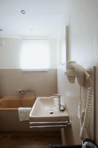 a bathroom with a sink and a bath tub at Hotel Am Waldschwimmbad in Bürstadt +14 photos