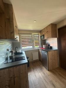 a kitchen with wooden cabinets and a stainless steel refrigerator at Noclegi nad Zaporą in Międzybrodzie Bialskie