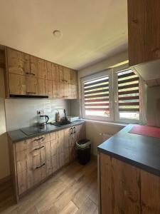 a kitchen with wooden cabinets and a black counter top at Noclegi nad Zaporą in Międzybrodzie Bialskie