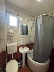 a bathroom with a toilet a sink and a shower at Apartmani Čavor in Budva +18 photos