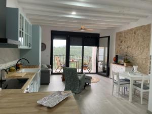 a kitchen and living room with a view of a balcony at Les Casetes in La Senia