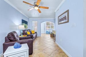 a living room with a couch and a ceiling fan at Barefoot Beach Resort F104 in Clearwater Beach +26 photos
