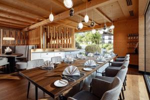 a dining room with a large wooden table and chairs at Boutique Hotel Nives - Luxury & Design in the Dolomites in Selva di Val Gardena