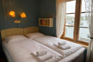a bed with towels on it in a room with a window at The traditional Burekka 17 - Lofoten in Stamsund