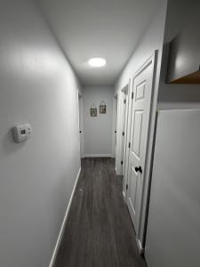 an empty hallway with white walls and a white door at Crewe Corner D in Crewe
