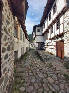an alley in an old town with buildings at Валериевата Къща 2 in Shiroka Laka