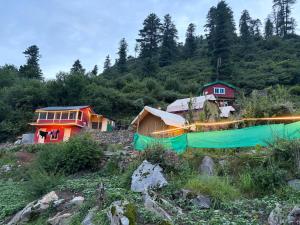 a group of houses on a hill with trees at Skyblue cafe in Tosh